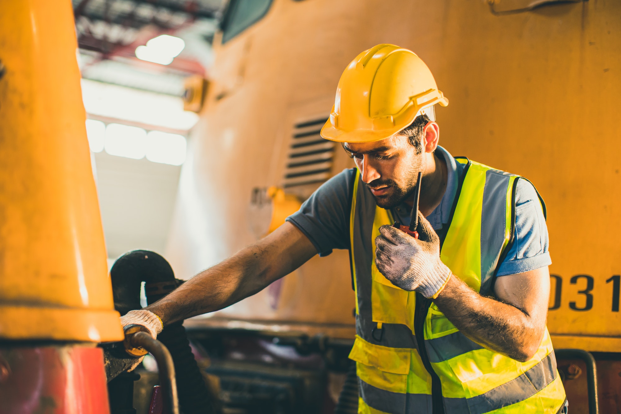male worker hispanic latin foreman radio control operate working in locomotive workshop industry